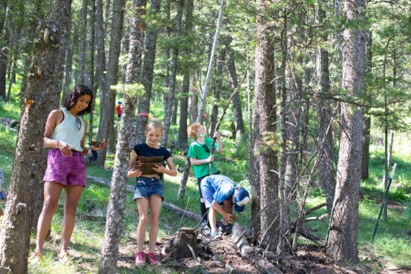 Young learners explore in the woods.