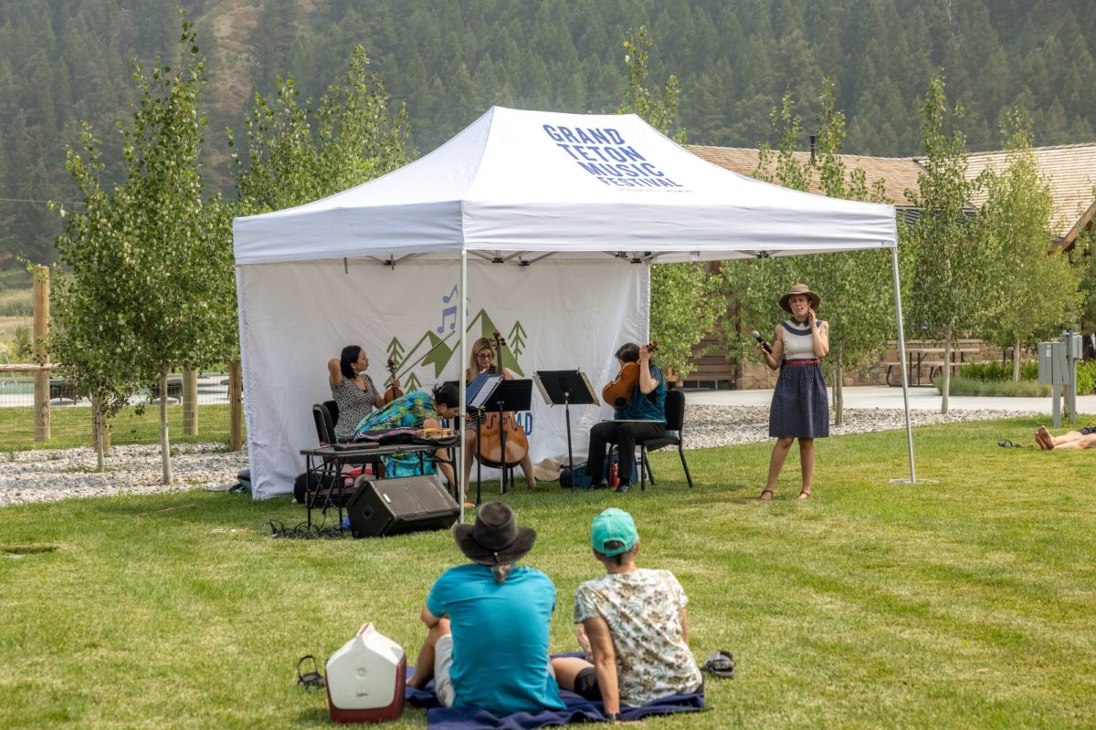 Performers play under a Grand Teton Music Festival tent on a grassy lawn.