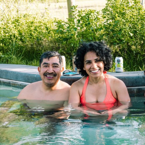 A Latino couple enjoys a hot spring on a sunny day.