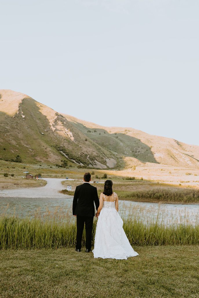 A bride and groom pose in front of the Snake River at Astoria Hot Springs.
