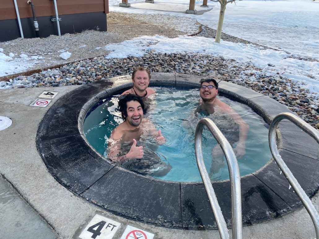 Three men dip in the cold plunge pool at Astoria Hot Springs.